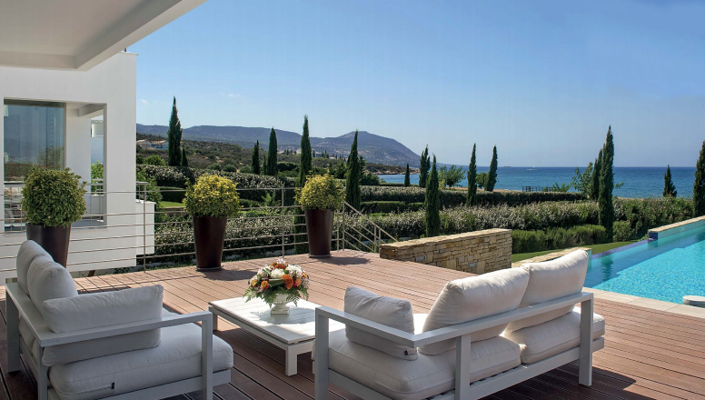 villa deck with pool and view of forest and ocean of Paphos Cyprus in background