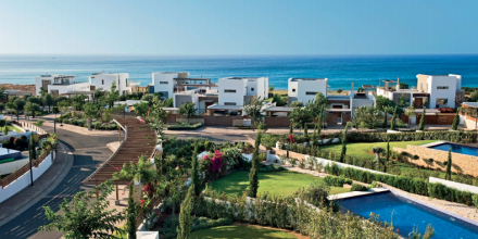 external view of complex with villas and garden with ocean inthe background